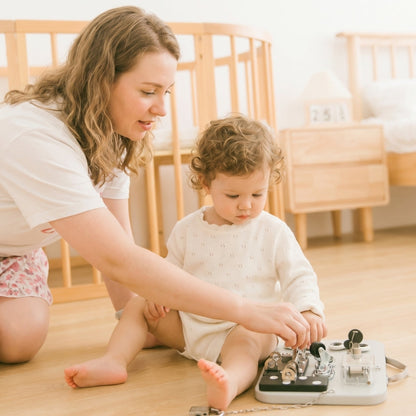 Enfant ouvrant un loquet sur un tableau Montessori