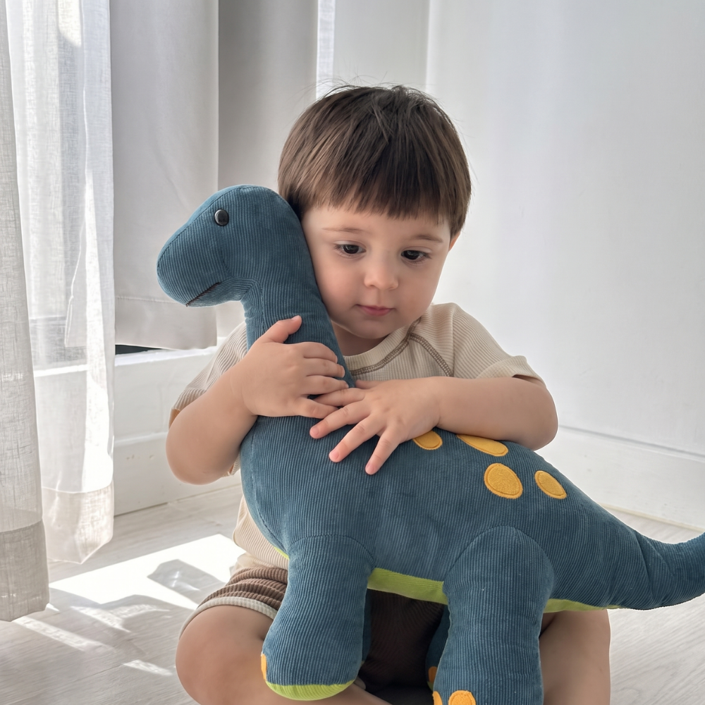 Peluche dinosaure moelleuse présentée sur un fond clair