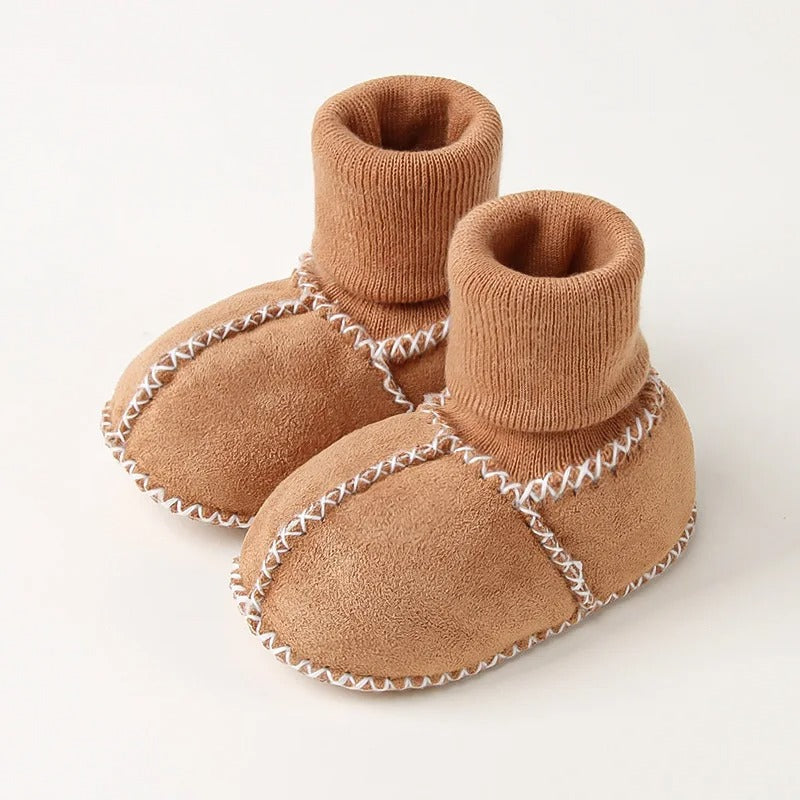 Détail de la texture douce du tricot des chaussons bébé