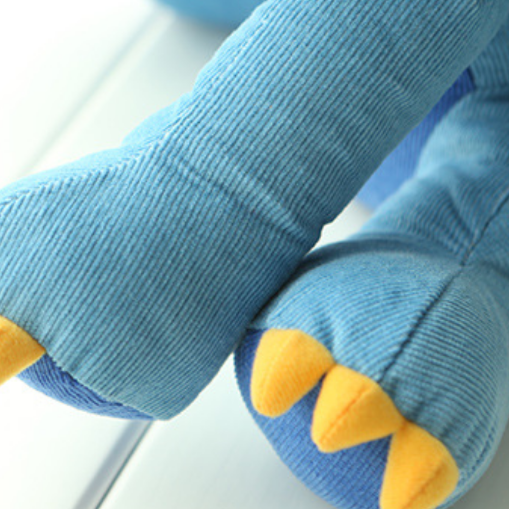 Peluche dinosaure installée sur un lit d’enfant
