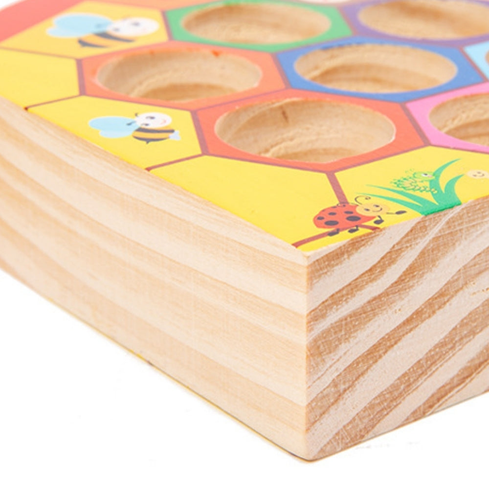 Alvéoles en bois accueillant les abeilles colorées du jeu