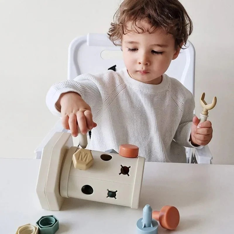 Enfant manipulant le jouet Montessori pour développer sa motricité fine