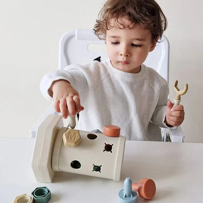 Enfant manipulant le jouet Montessori pour développer sa motricité fine
